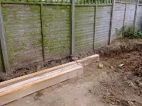 Laying the sleepers along the fence to give a narrow bed.